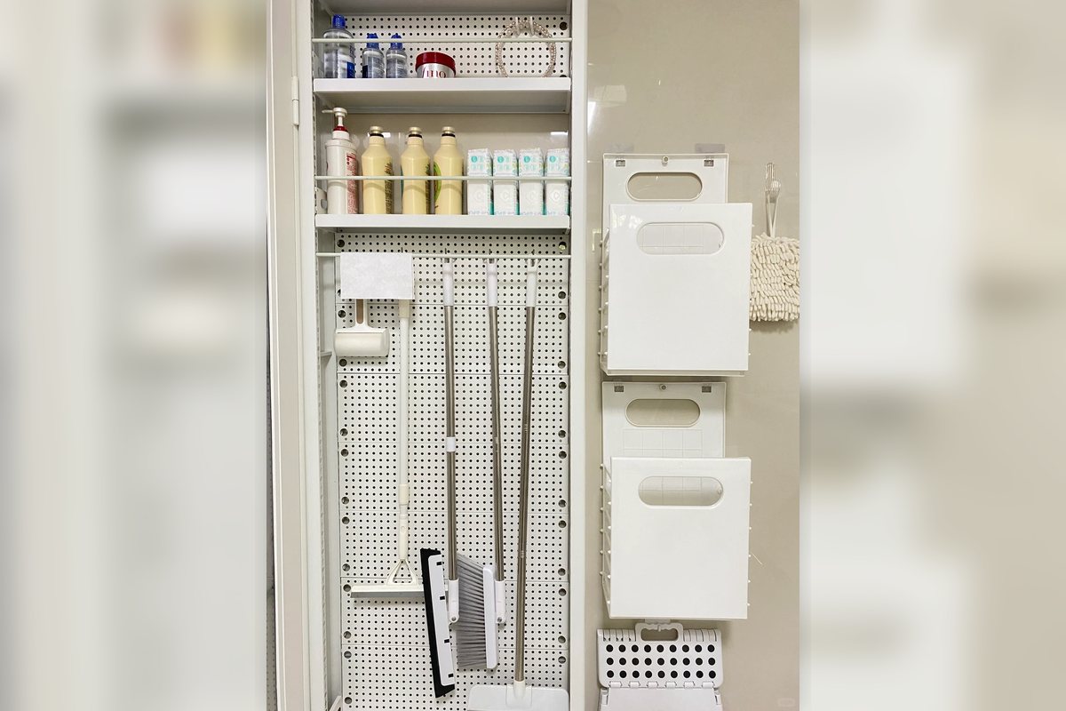 Slim bathroom cabinet and pegboard storage fitted into a narrow wall zone.