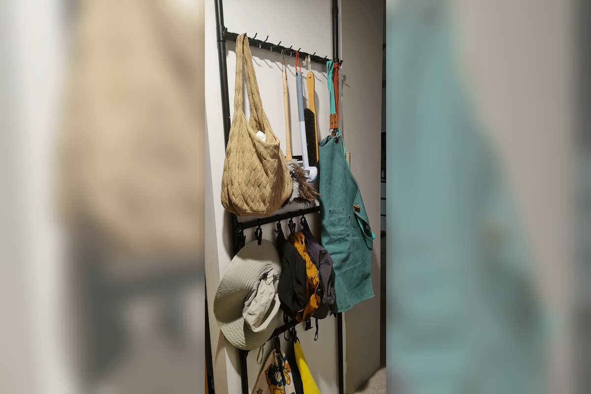 Close view of a no-drill hanging hook rail holding bags and accessories.