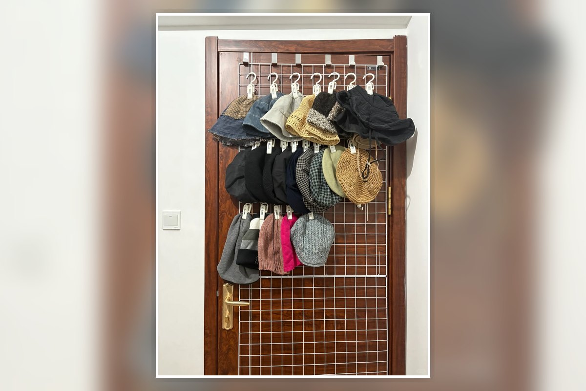 No-drill over-door grid organizer holding hats and bags on the back of an apartment door.